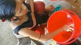 Village girl from India bathes in the open air