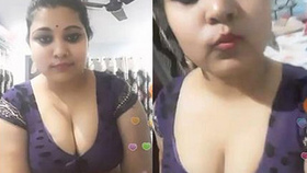 Voluptuous Indian woman with large breasts removes her saree and displays her stomach in a provocative manner